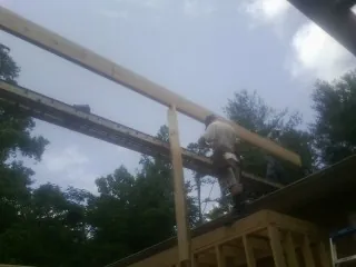Carpenter setting a ridge beam over a new addition frame — Ice Dam Removal by Roofing Brothers in Maple Plain